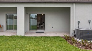 Ein modernes, zweistöckiges Gebäude mit flachem Dach, großen Fenstern und einem überdachten Eingang.