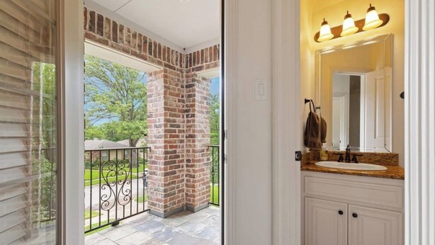 A bathroom with a white vanity, a mirror, and a light fixture above the mirror. - Huge Home w/ Gameroom, Patio, & Secret Room! (Dallas)