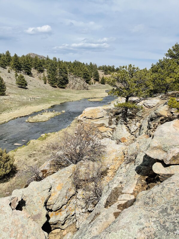Une rivière qui traverse un paysage rocheux, où la végétation est rare et le ciel est dégagé.