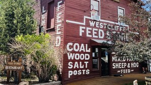 Un edificio rojo con letreros que anuncian 'The Feed Store Restaurant' y 'Westcliffe Feed'.