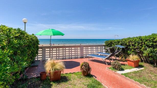 Un espace patio aménagé avec une table de billard, des plantes en pot et une vue sur la plage.