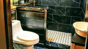 A modern bathroom with a white toilet, a sink, and a mirror. - The Oaklyn Container ~ Hocking Hills ~ Hot tub ~ Firepit ~ Wifi (Logan)