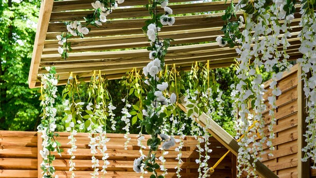 A wooden deck with a hammock, a round table with fruit, and a bench. - The Majestic Garden Suite (Paris)