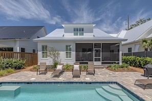 A house with a pool, a covered patio, and a screened porch.