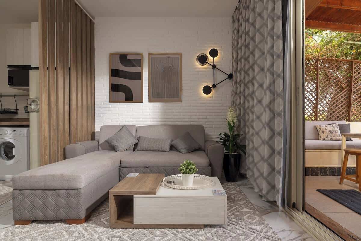 Una sala moderna con un sofá modular, una mesa de centro y un aplique de pared.