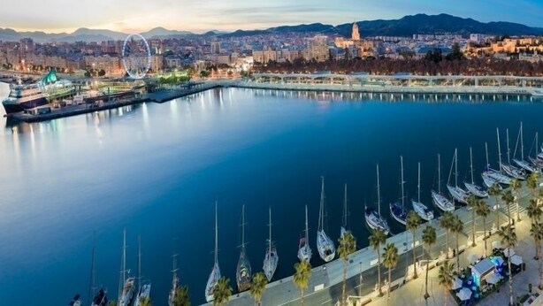 A marina with boats docked, a Ferris wheel, and a cityscape in the background. - Family house in a quiet university neighborhood (Málaga)