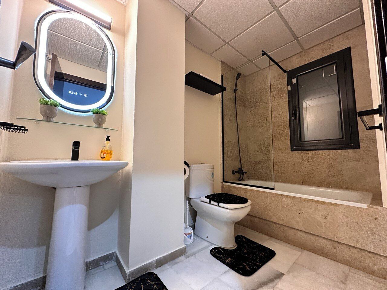 Un baño con lavamanos, inodoro y bañera blancos.