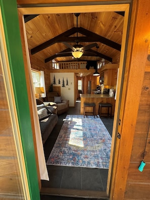 A wooden cabin interior with a living room, kitchen, and dining area. - Serenity Ridge Cabin C: Couple's Escape (Mill Spring)