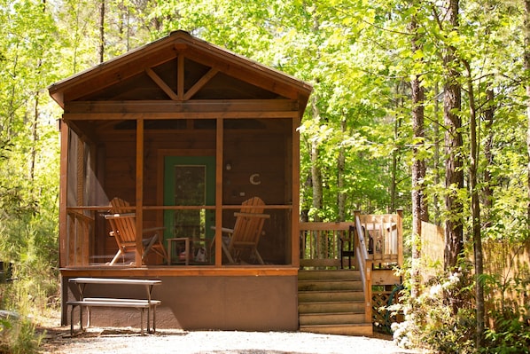 A wooden cabin with a porch, two chairs, and a bench. - Serenity Ridge Cabin C: Couple's Escape (Mill Spring)