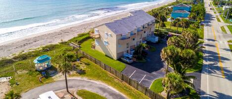 A beachfront hotel with a pool, a gazebo, and a view of the ocean.