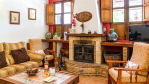 Ein gemütliches Wohnzimmer mit Kamin, Holzmöbeln und verschiedenen Dekorationselementen.