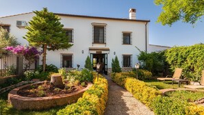 Une maison à deux étages avec un jardin et un chemin qui mène à l’entrée.
