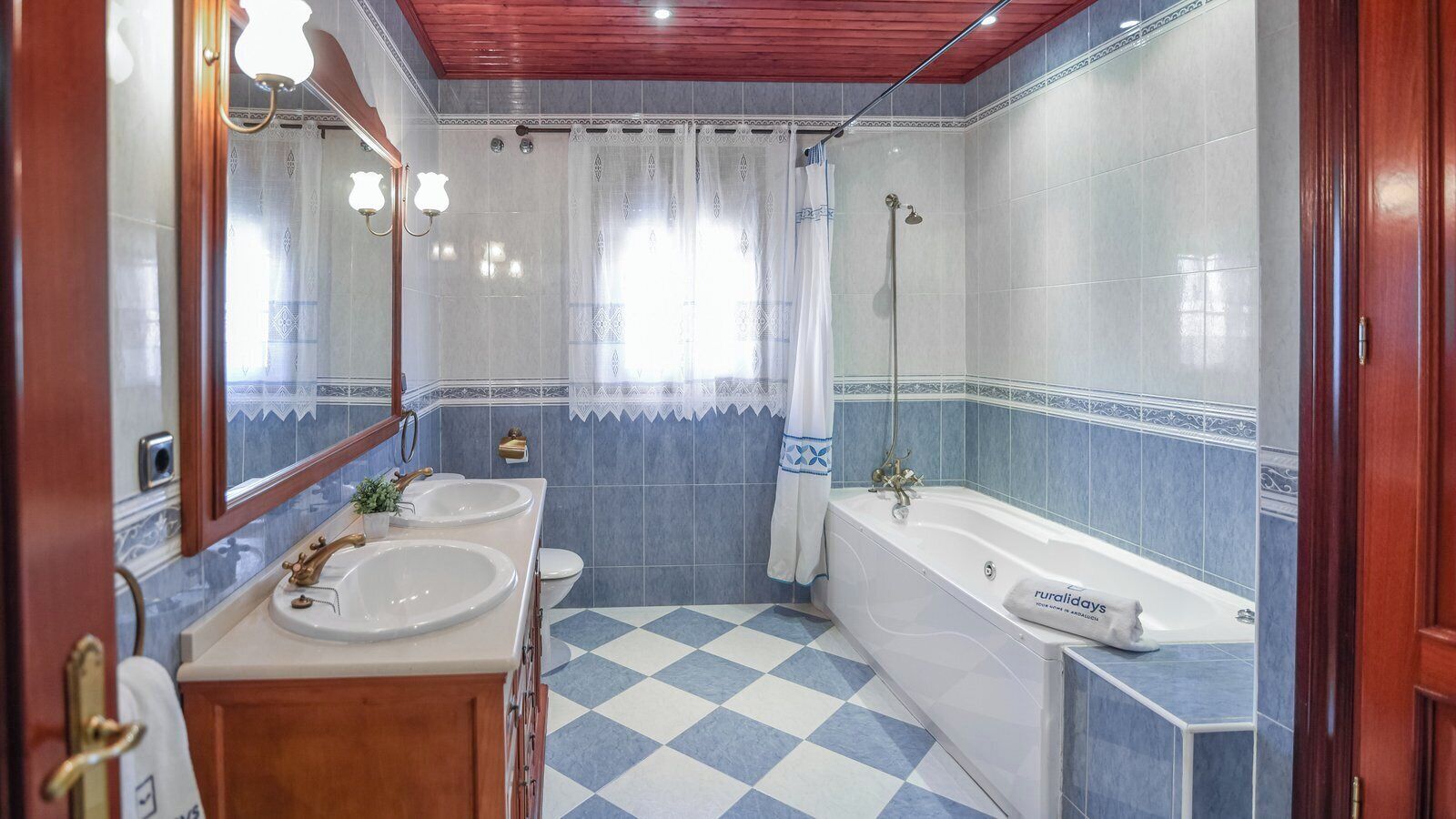Un baño con dos lavamanos, un inodoro, una bañera y una ducha.