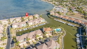 Vista aérea de una zona residencial costera con un puerto deportivo, casas y una gran masa de agua.