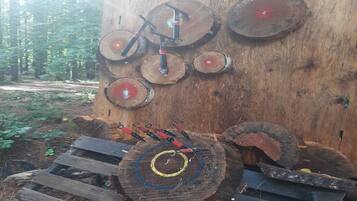 Een houten constructie met meerdere ronde doelen, waarvan sommige een rode kern hebben, en een ladder die erheen leidt.