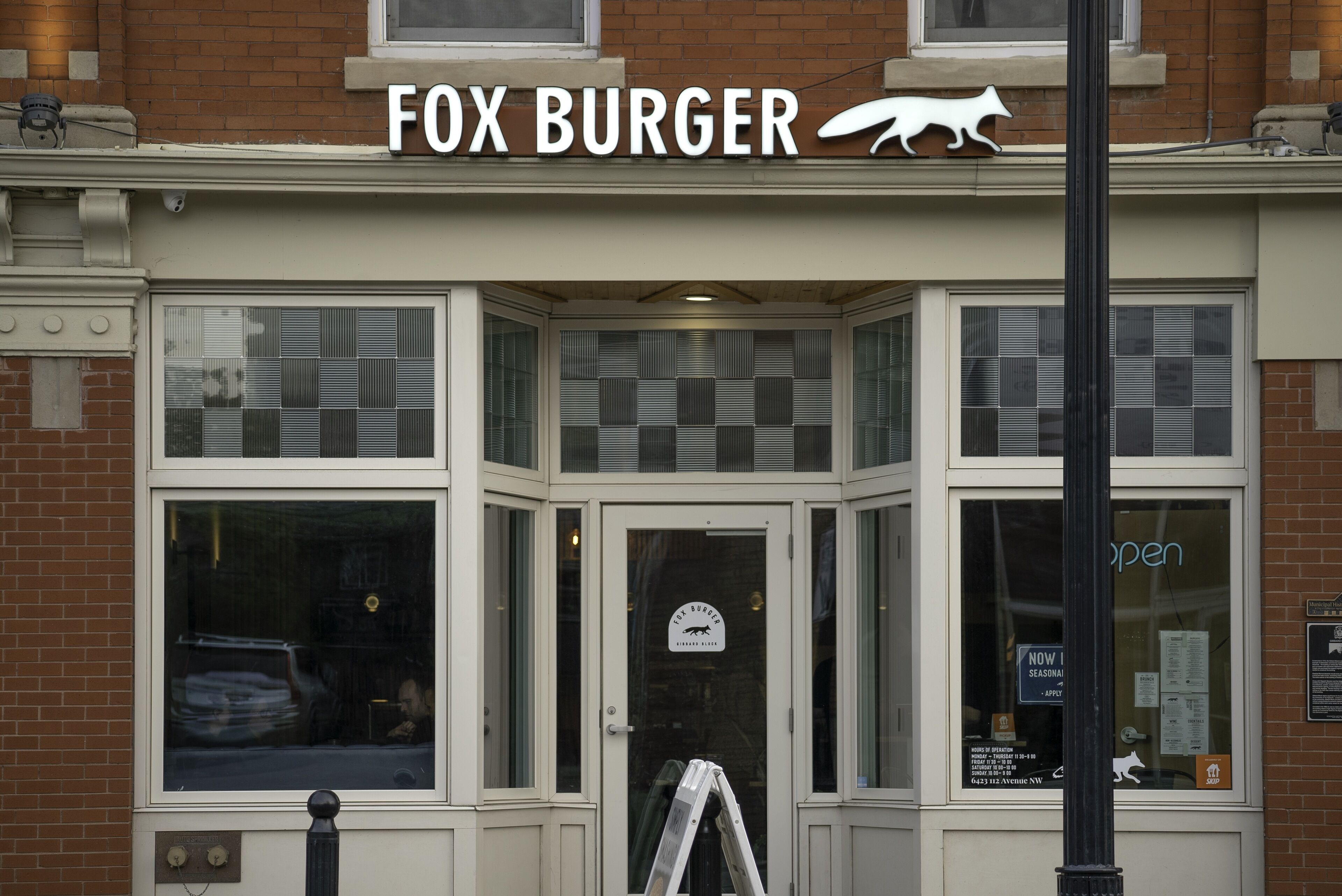 Un edificio con un letrero que dice "FOX BURGER" y un logotipo de un zorro.