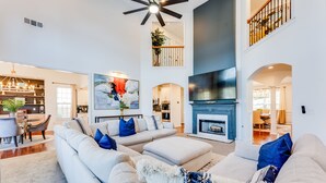 A spacious living room with a large sectional sofa, a fireplace, and a flat-screen TV.