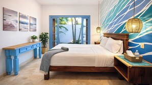 A bedroom with a bed, a nightstand, a desk, and a window with a view of palm trees. - Spacious 2BR w/ Pool •  Walk to Beach & Town • Quiet area (Sayulita)