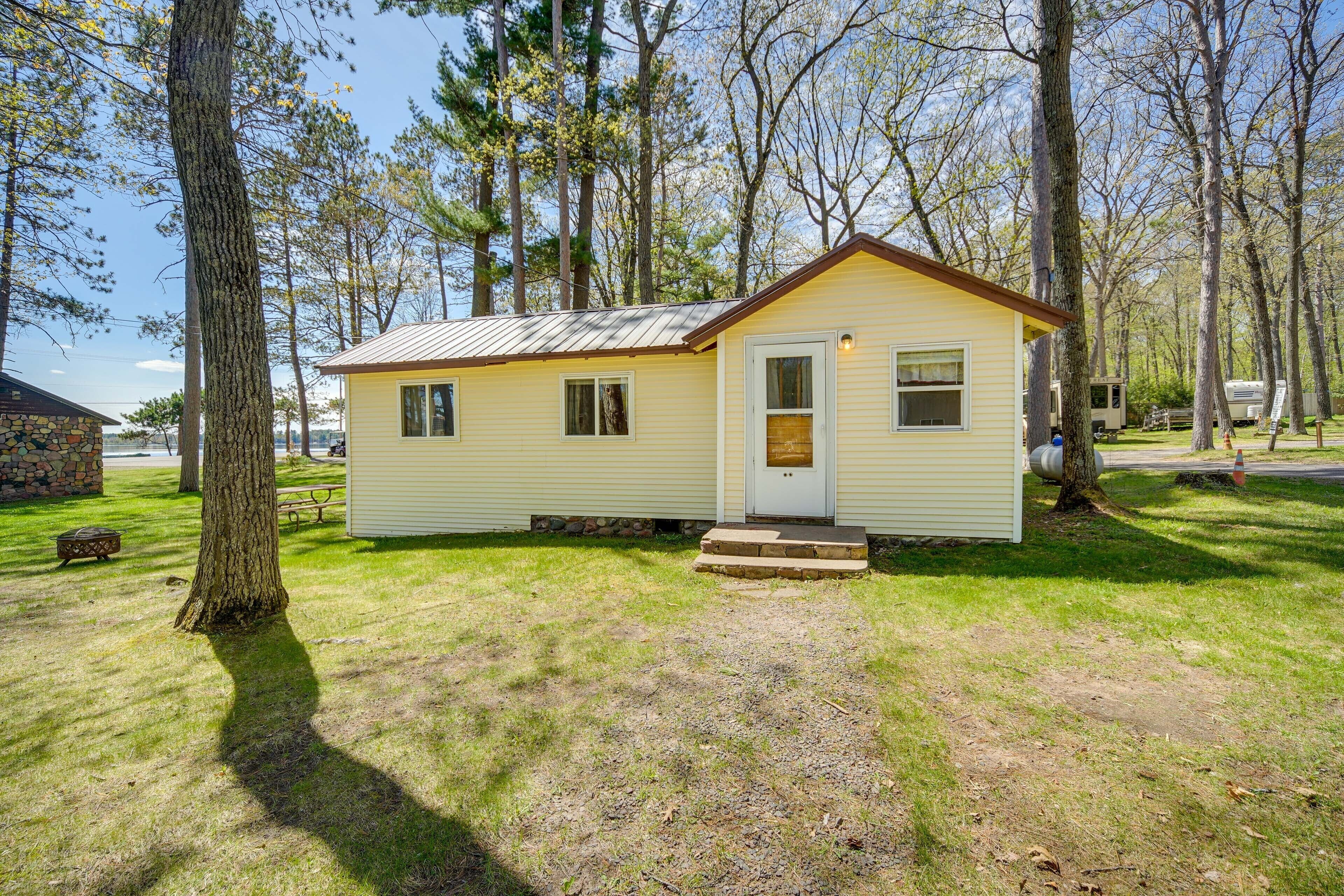 A small, single-story cabin with a front door, a small porch, and a window.