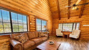 A log cabin interior with a leather sofa, a wooden coffee table, and two white armchairs. - Bodfish Ranch/ sleeps 14 / secluded on 3.5 acres (Bodfish)