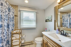 Een badkamer met toilet, wastafel en douchegordijn.