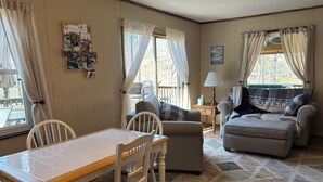 Un salon chaleureux avec une table à manger, deux canapés et un tapis.