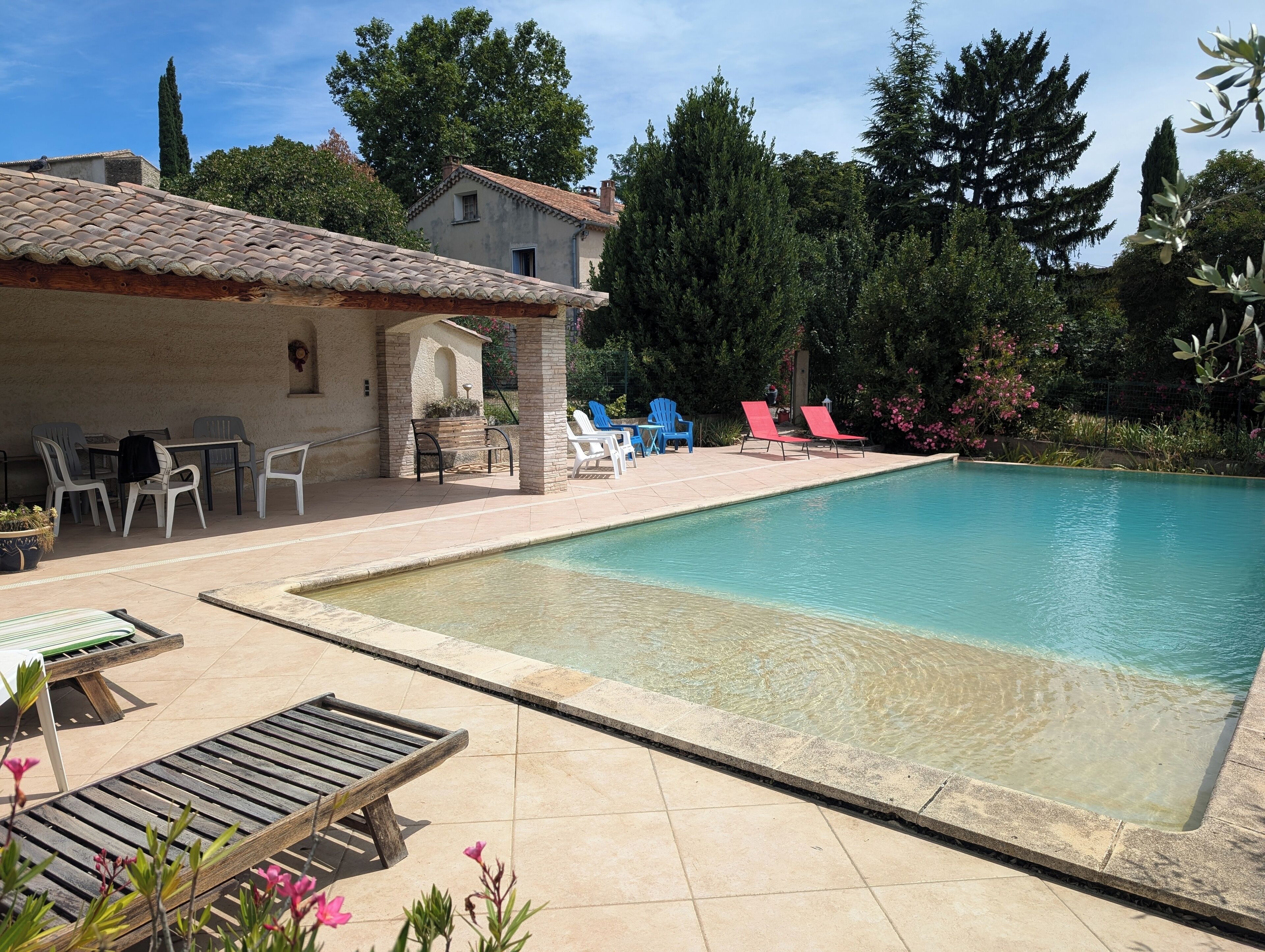 A swimming pool with lounge chairs and a patio area.