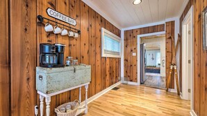 Ein Holzinterieur mit einer Kaffeebar, einer Keurig-Kaffeemaschine und einem rustikalen Tisch.
