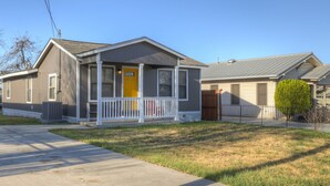 A single-story house with a front porch, a visible garage door, and a small front yard.
