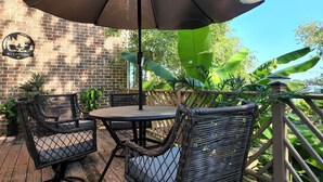 An outdoor patio with wicker chairs, a table, and a large umbrella. - Relaxing Luxurious Waterfront in Hampton  (Hampton)