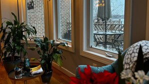 A cozy room with a view of a balcony, large windows, and potted plants. - Relaxing Luxurious Waterfront in Hampton  (Hampton)