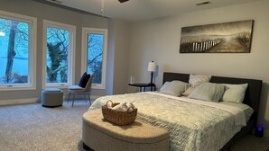 A bedroom with a bed, a chair, a lamp, and a painting on the wall. - Relaxing Luxurious Waterfront in Hampton  (Hampton)