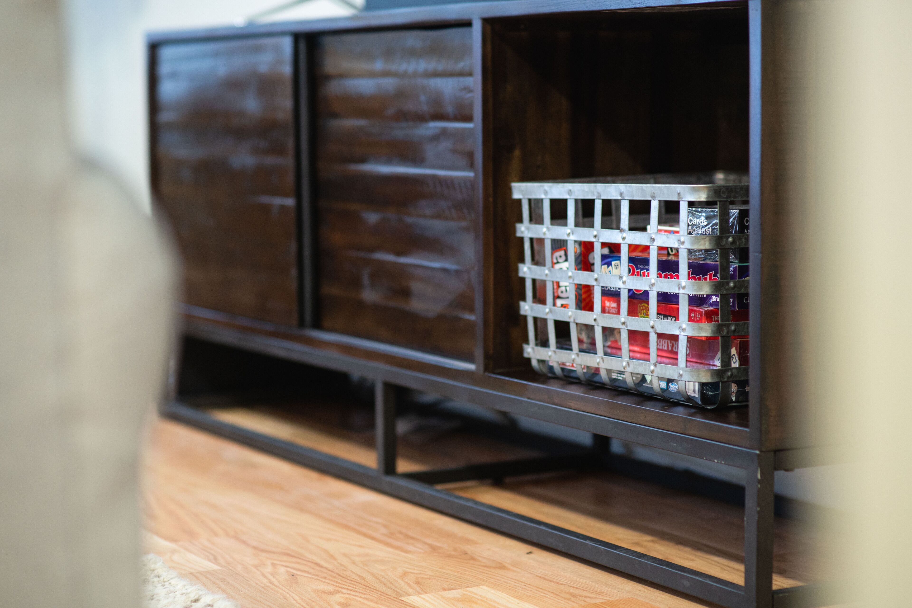 A wooden cabinet with metal shelves, one of which contains a grid of red and white boxes.