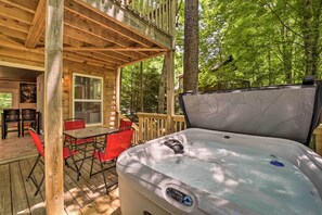 A wooden deck with a hot tub, outdoor seating, and a view of the forest. - Private Hot Tub, Yard: Pet-Friendly Whittier Cabin (Whittier)