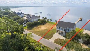 A residential area with houses, a dock, and a large body of water. - Newly built house located on the bay (Pace)