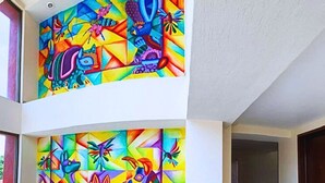 A spacious interior with a black sofa and vibrant abstract wall art. - Hotel Express Inn Ixtepec (Ixtepec)