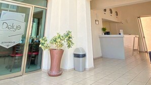 A hotel lobby with a colorful mural, a reception desk, and a potted plant. - Hotel Express Inn Ixtepec (Ixtepec)