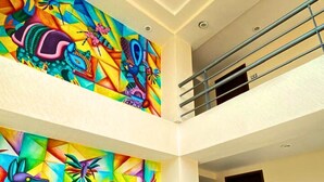 A spacious lobby with a black sofa and vibrant abstract wall art. - Hotel Express Inn Ixtepec (Ixtepec)