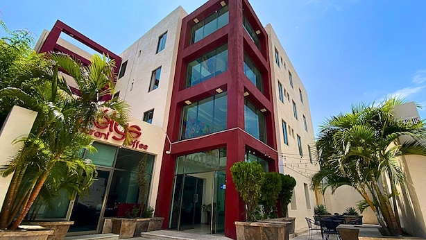 A modern building with a coffee shop on the ground floor, large windows, and a well-maintained outdoor area with plants. - Hotel Express Inn Ixtepec (Ixtepec)