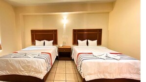 A hotel room with two beds, each with a wooden headboard, white bedding, and striped blankets. There is a nightstand with a lamp and a phone between the beds. - Hotel Express Inn Ixtepec (Ixtepec)