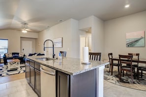 A modern kitchen with granite countertops, stainless steel appliances, and a central island.