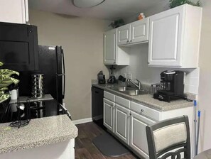 Prepare meals in this kitchen with a refrigerator, dishwasher, and coffee maker.