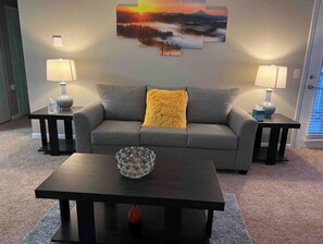 Relax in this inviting living space with a sofa, side tables, and a coffee table.