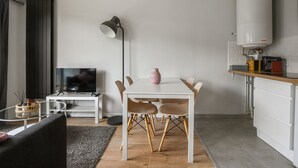 Un espace de vie moderne comprenant un coin repas, un téléviseur et une cuisine.