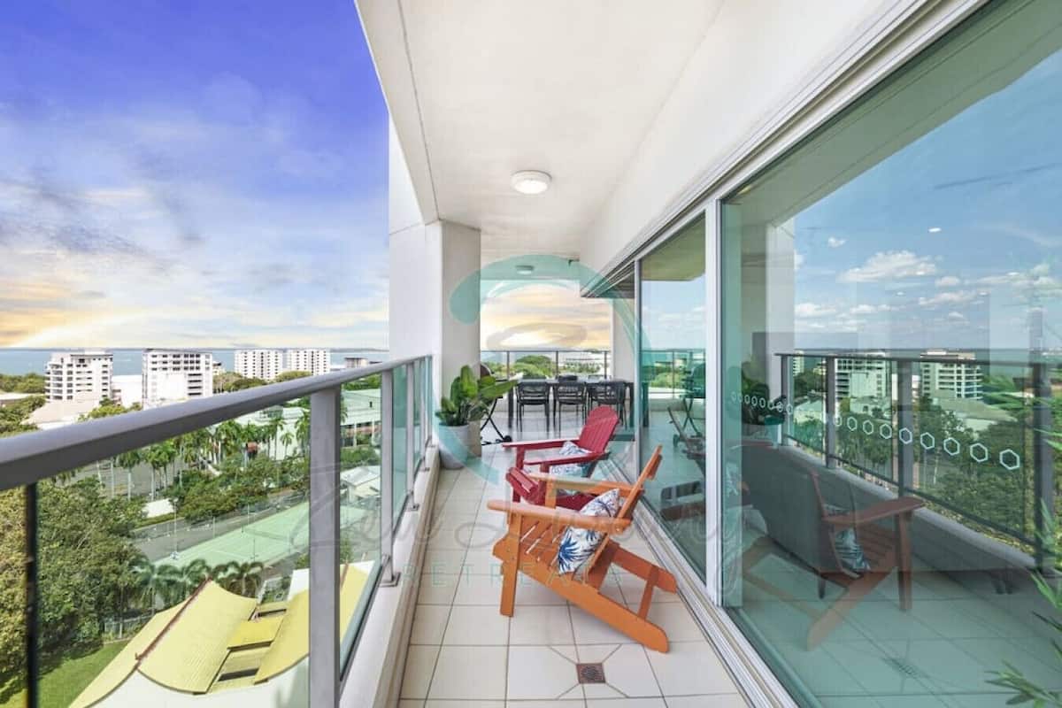 A balcony with a view of a cityscape and a body of water.