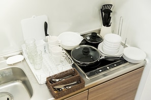 Kylskåp, mikrovågsugn, spishäll och grytor/köksredskap