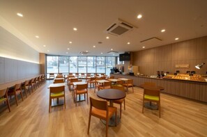 Relax in this stylish indoor space with long tables, round tables, and a flat-screen TV.
