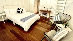 Habitación de hotel con una cama, un escritorio, una silla y una escalera.
