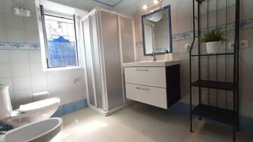 Un baño con inodoro, lavamanos y ducha.