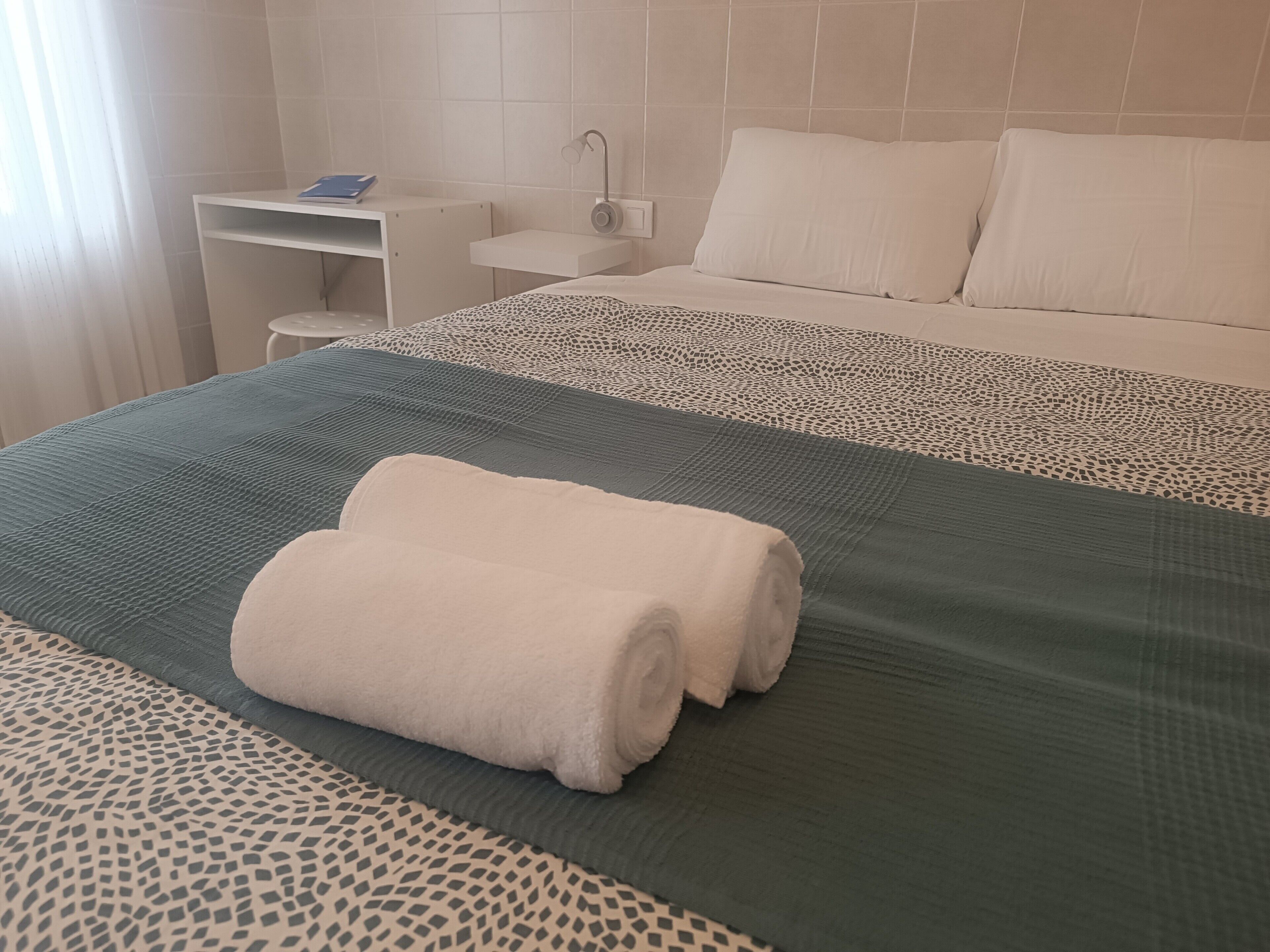 Una habitación de hotel con una cama, un escritorio y una silla.